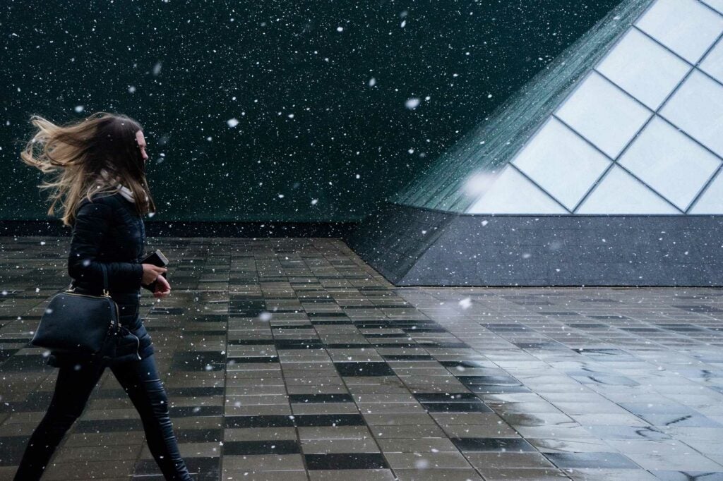 a woman walks through snow