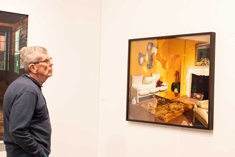 man looking at photograph on the wall