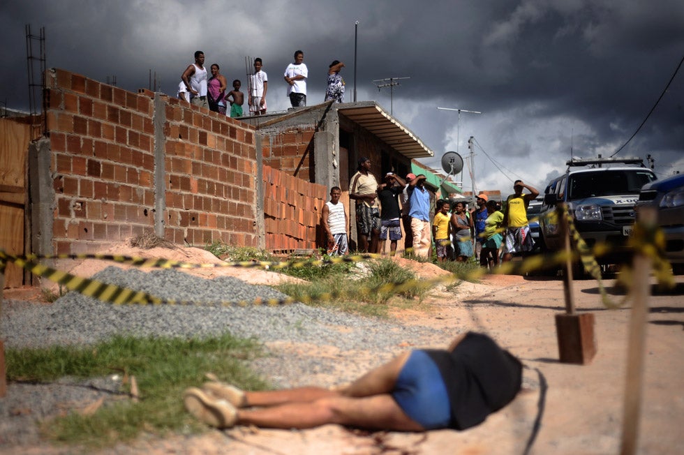 Residents observe the body of an individual killed by street violence in the slums of Salvador, Brazil. Authorities are worried about the 250% increase in murder rate in what is one of Brazil's main tourist cities, as well as a 2014 World Cup host city. Lunae Parracho is a Brazilian-based photojournalist stringing for Reuters. See more of his work <a href="http://www.americanphotomag.com/photo-gallery/2012/10/photojournalism-week-october-12-2012?page=8">here</a>.