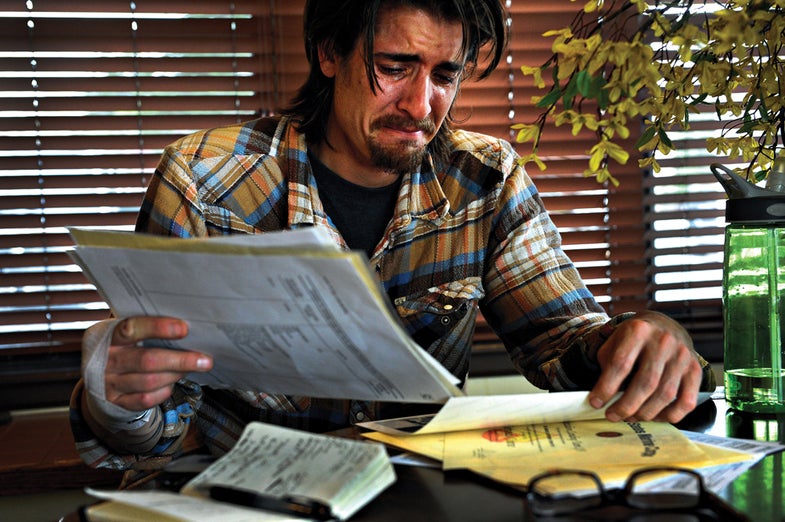 Scott looks over his military service records and weeps after being told his apartment application had been turned down. The leasing manager said he couldn't allow Scott to move in because of an assault charge on his background check. Though Scott had his honorable discharge papers and his good-conduct medal, Scott said they meant nothing. "I'm not a criminal. You would think this would be worth something. It should be. It's not, though."