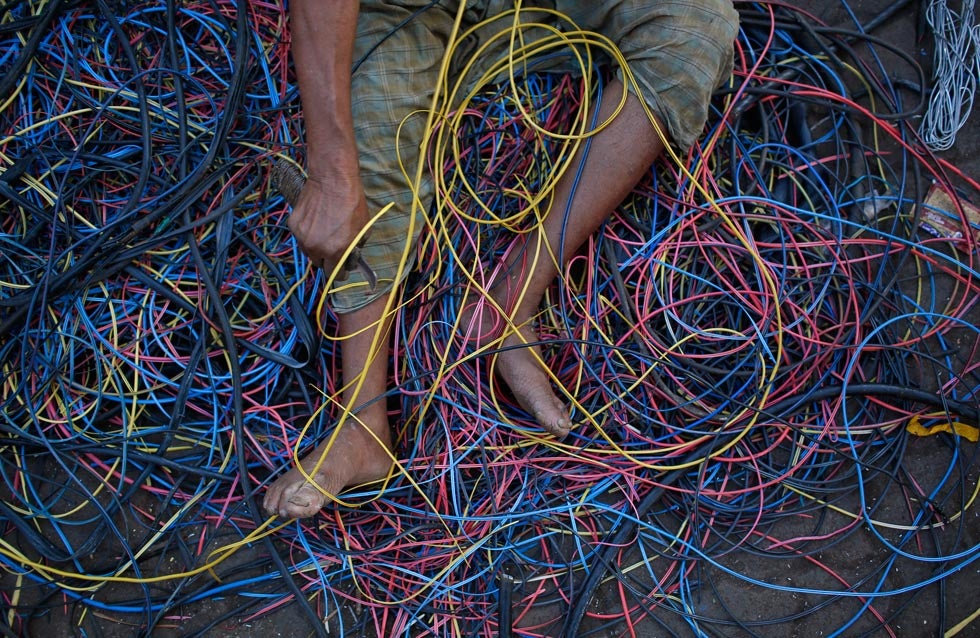 A man removes copper wiring from electrical cables outside a scrap shop in Dharavi, Mumbai. Danish Siddiqui is a Reuters staffer based in India. You can keep up with his work by following his <a href="http://blogs.reuters.com/danish-siddiqui/">Reuters blog</a> and his <a href="http://blogs.reuters.com/danish-siddiqui/">Twitter</a>.