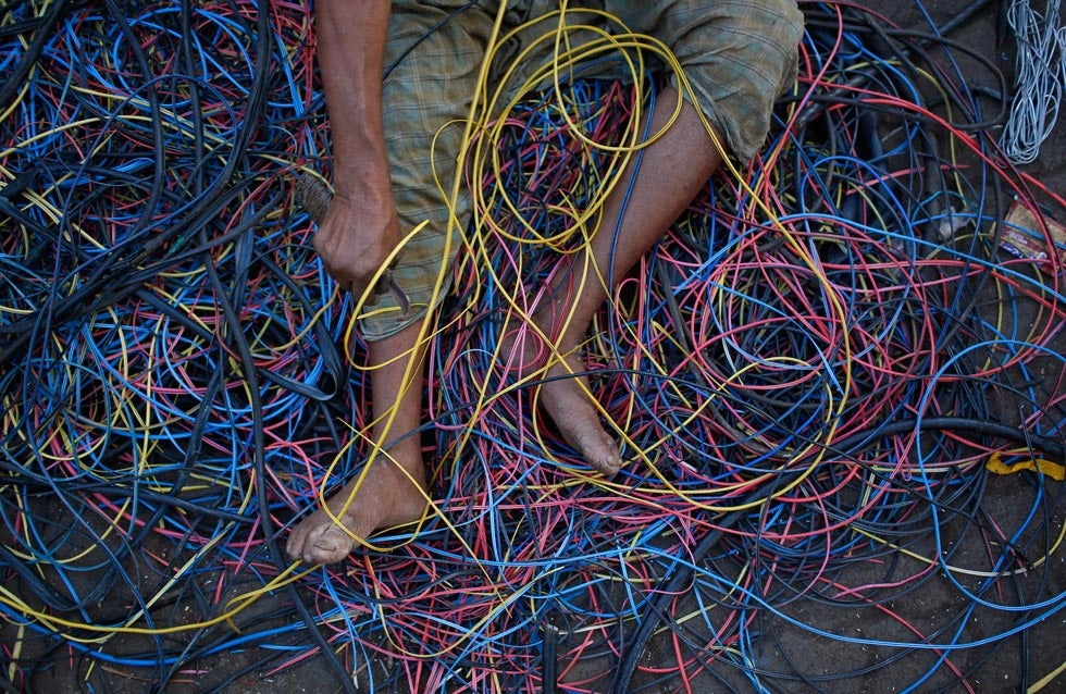 A man removes copper wiring from electrical cables outside a scrap shop in Dharavi, Mumbai. Danish Siddiqui is a Reuters staffer based in India. You can keep up with his work by following his <a href="http://blogs.reuters.com/danish-siddiqui/">Reuters blog</a> and his <a href="http://blogs.reuters.com/danish-siddiqui/">Twitter</a>.