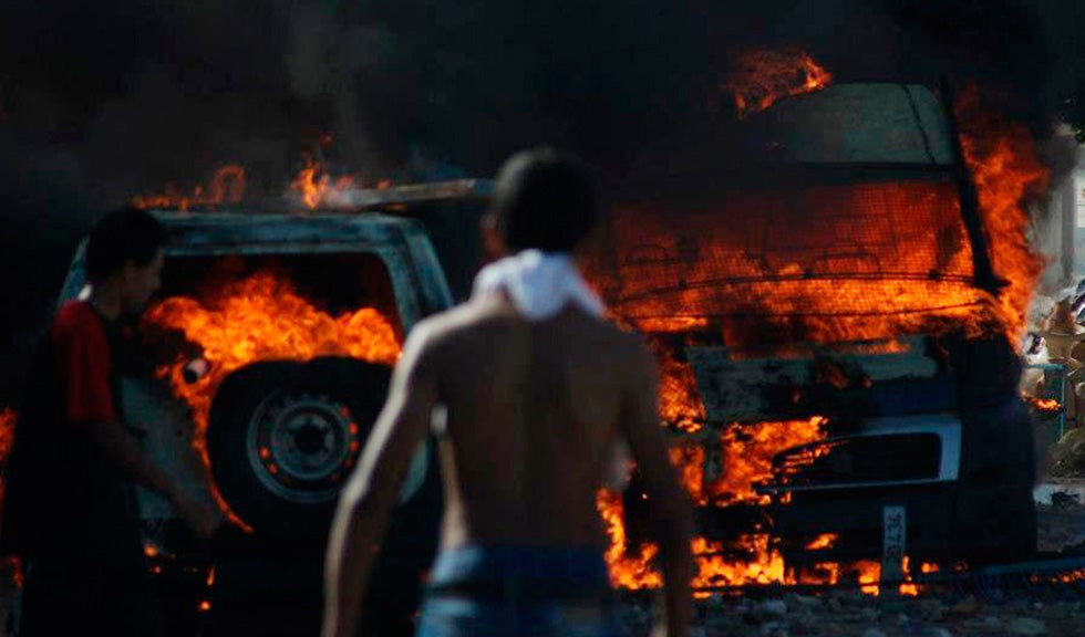 Police cars burn after being set ablaze by protesters demonstrating against the reopening of a rubbish dump in the town of Guellala on the island of Djerba, off the coast of Tunisia.