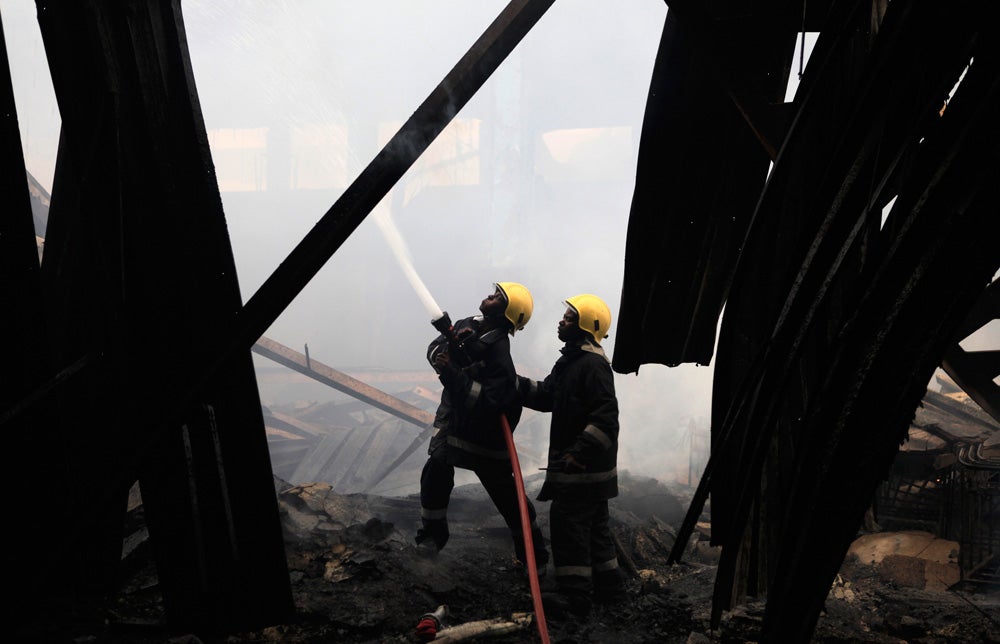 Fire fighters struggle to put out a fire at the Jomo Kenyatta International Airport in Kenya's capital Nairobi August 7, 2013. A fire engulfed Kenya's main airport on Wednesday, choking a vital travel and trade gateway to east Africa, witnesses and officials said. The cause of the fire was not yet known. REUTERS/Noor Khamis (KENYA - Tags: DISASTER TRANSPORT) - RTX12CJX