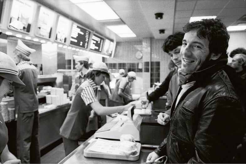 Photographer Jim Marchese joined Springsteen’s 1981 tour for “The River” in Europe, where local eateries were not always attuned to Bruce’s taste buds. “When we got to a new town,” Marchese recalls, “the joke was that there was a $5 tip for whomever in the crew spotted ‘the arches’ first.” That is, McDonald’s, where Bruce orders a meal.