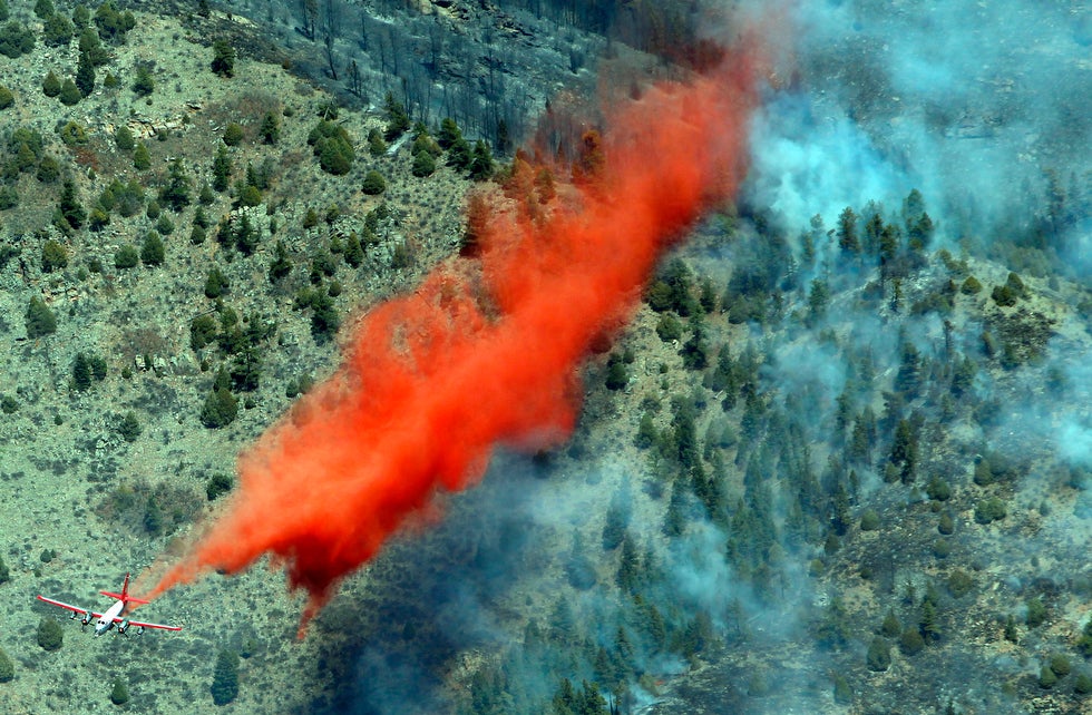 Firefighters douse a smoldering ridge southwest of Denver with slurry. The blaze has already destroyed 16 homes in the area and continues to spread. David Zalubowski is a former Associated Press staffer who now operates his own commercial studio in Colorado.