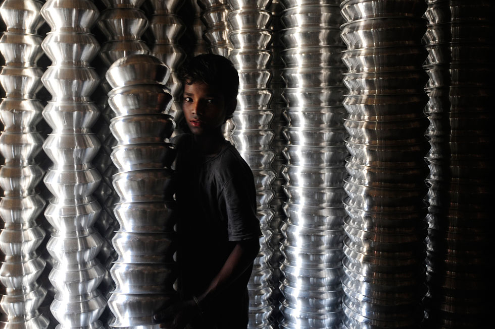 A boy poses in an aluminum pot-making factory, where he works, in Dhanka, Bangladesh. UNICEF estimates that somewhere around 6.3 million children under 14 are currently working in Bangladesh. Munir Uz Zaman is a freelance photographer, working for AFP in the Dhanka region.