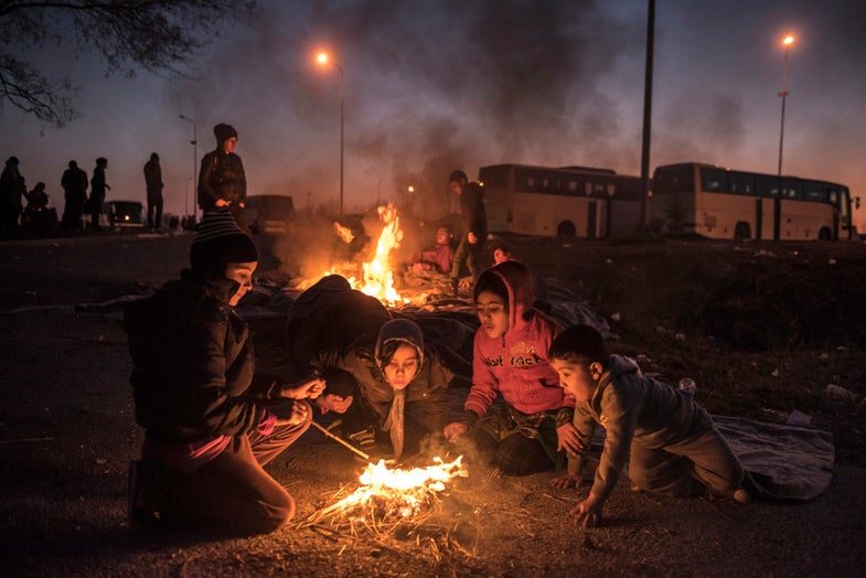 Migrant kids lit the bonfire to warm themselves at the gas station on the highway where they wait to get transited to the Idomeni registration camp on the Greek-Macedonian border, Thursday January, 28, 2016.