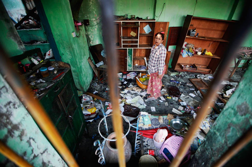 A Muslim woman salvages items from her home damaged during rioting in Meikhtila, Myanmar. Ethnic tensions in the region are at an all time high, threatening government stability.
