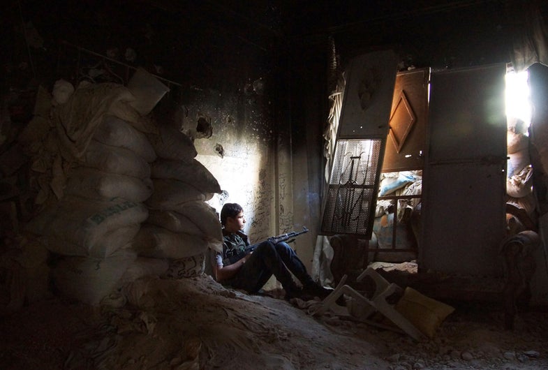 A Free Syrian Army fighter sits near sandbags inside a damaged room in Deir al-Zor August 18, 2013. Picture taken August 18, 2013. REUTERS/Khalil Ashawi (SYRIA - Tags: CONFLICT TPX IMAGES OF THE DAY) - RTX12QJM