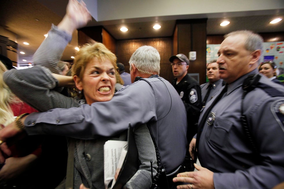 Abortion rights advocate Margaret Doyle is escorted from the Virgina General Assembly building, amid protests of a state senate committee's approval of a bill stating that human life begins at conception. The senate committee later withdrew support for the bill after facing widespread criticism nation-wide.