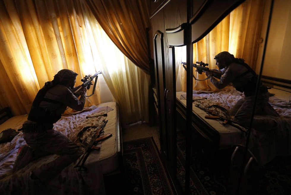 A fighter from the Sadik unit of Free Syrian Army's Tahrir al Sham brigade fires his Draganov sniper rifle from inside a house during heavy fighting in Mleha suburb of Damascus. Goran Tomasevic is a Reuters staffer who predominantly covers wars and conflicts. He has previously photographed in Libya, Syria, Egypt and Iraq. In 2003 and 2005 he was named Reuters' Photographer of the Year. See more of his work <a href="http://www.americanphotomag.com/photo-gallery/2012/11/photojournalism-week-november-9-2012?page=6">here</a>.