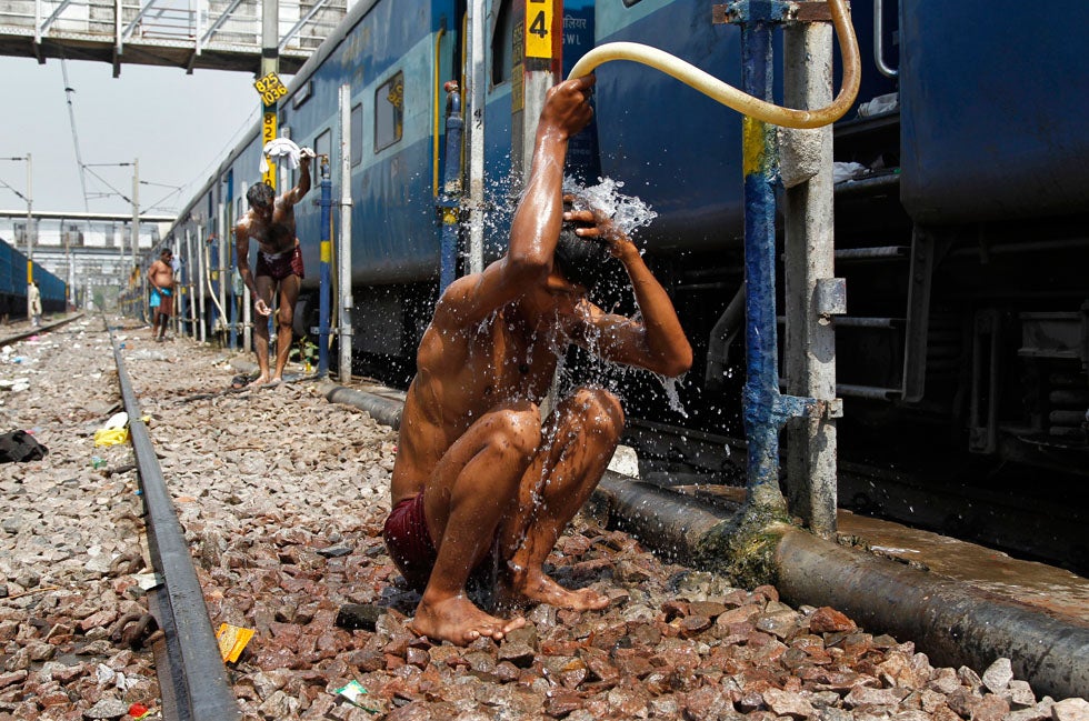 Young men in Allahabad, India, cool down from the mid-day sun using railroad water supply pipes at a local train station. Jitendra Prakash is a Reuters staffer based in central India.