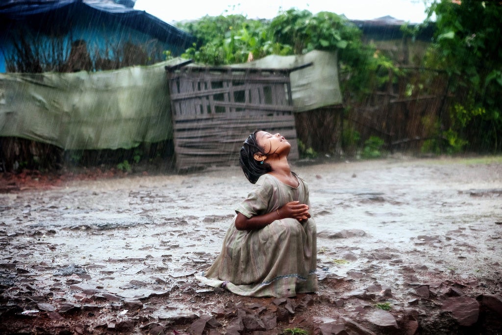 A Poonam, 8, is refreshing under the late monsoon rain in the impoverished Oriya Basti colony in Bhopal, Madhya Pradesh, India, near the former Union Carbide (now DOW Chemicals) industrial complex. When the heavy monsoon rain falls every year, it seeps through the buried waste of UC, before proceeding to fill up and pollute the area's underground reservoirs.