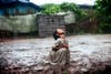 A Poonam, 8, is refreshing under the late monsoon rain in the impoverished Oriya Basti colony in Bhopal, Madhya Pradesh, India, near the former Union Carbide (now DOW Chemicals) industrial complex. When the heavy monsoon rain falls every year, it seeps through the buried waste of UC, before proceeding to fill up and pollute the area's underground reservoirs.