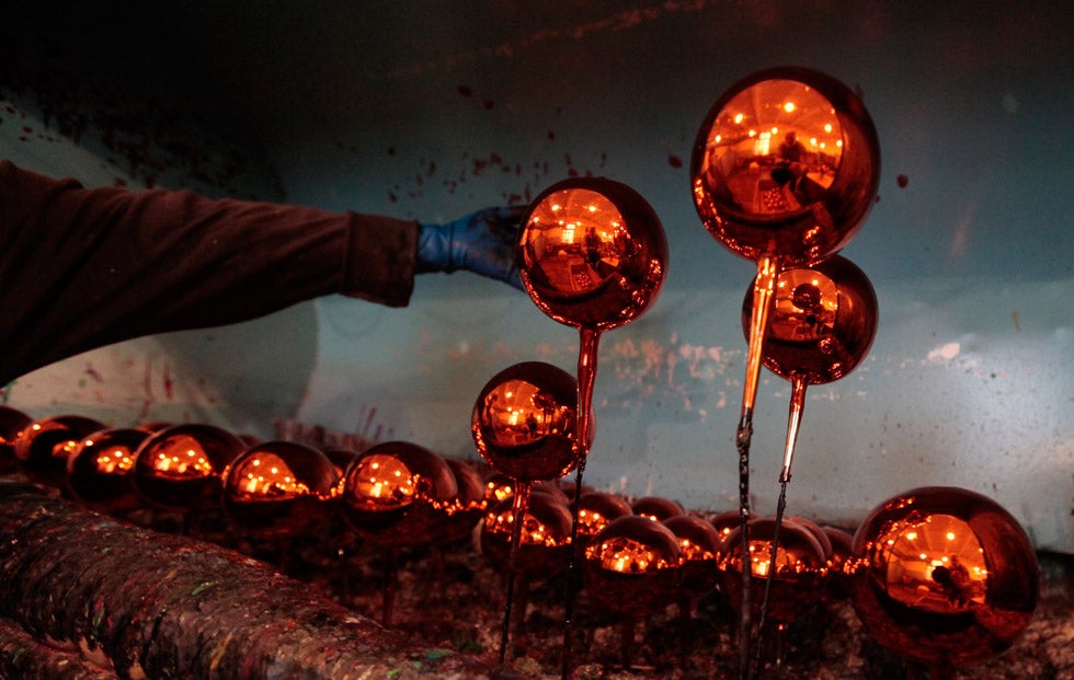 An employee places a newly painted glass Christmas decoration in a drying rack at the "Biryusinka" toy factory in Russia's Siberian city of Krasnoyarsk. Ilya Naymushin is a Reuters staffer based in Siberia.