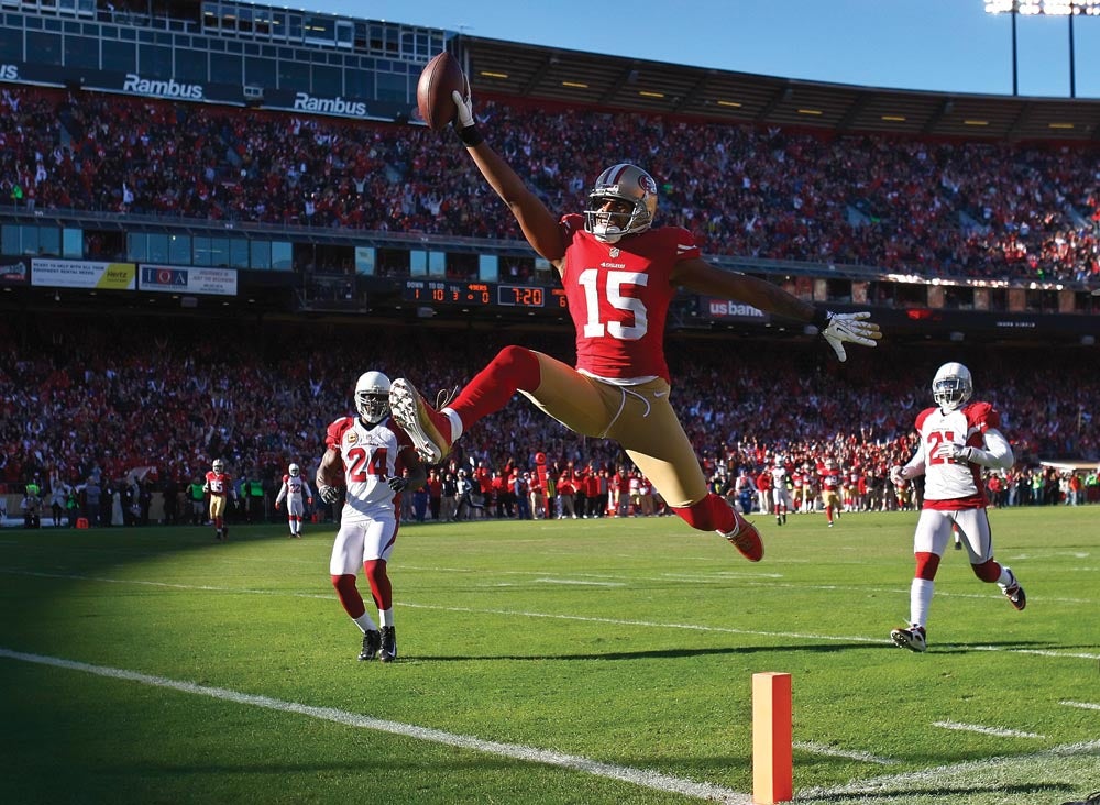 At first glance, Gonzalez's photograph of San Francisco 49ers wide receiver Michael Crabtree appears to be one of those iconic images of hard-won football glory. Look again—at the exuberance, at the opposing team standing by almost in awe. This touchdown was one of three the soon-to-be conference champions scored against the Arizona Cardinals, who ended this final regular-season game having lost 11 of their last 12 match-ups. It is Goliath beating David, with perfect theatrical lighting provided by the Almighty. When Crabtree glided through the air into the end zone, the longtime San Francisco Chronicle photographer responded with the intuition that comes with years of practice. "I reached for my short-lens [16–35mm] camera, and I don't even remember putting it up to my eye," Gonzalez says. The result: a terrific portrait. "You really get a sense of his personality," he says
