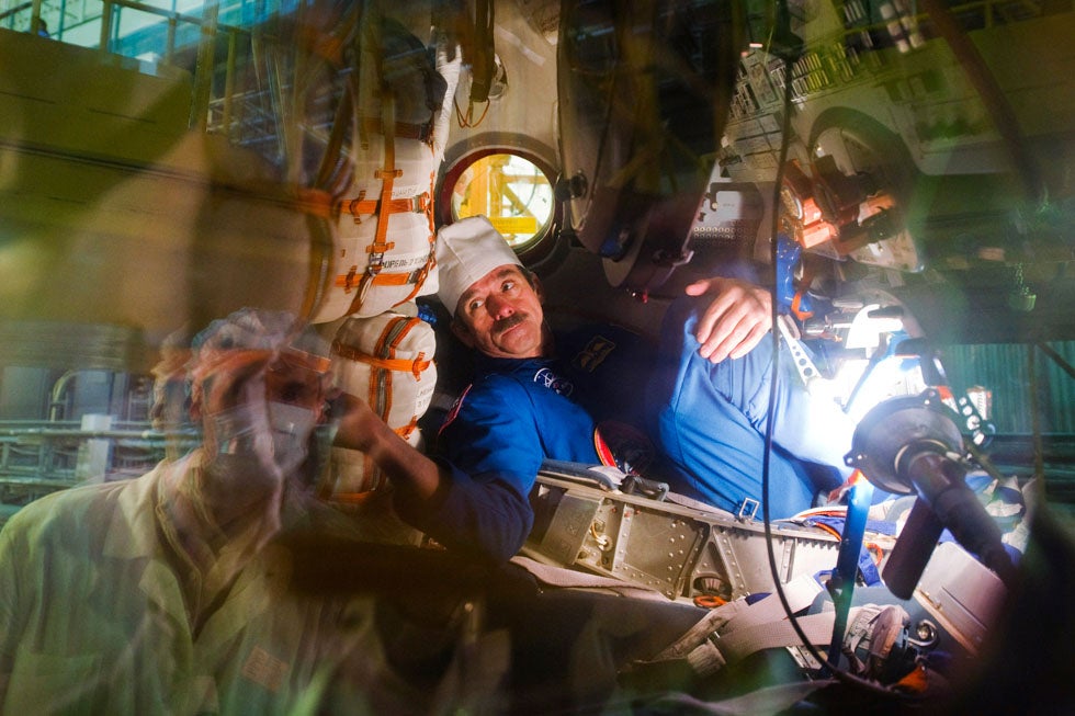 The International Space Station (ISS) crew member Canadian astronaut Chris Hadfield is pictured through a window attending a training at Baikonur cosmodrome. Hadfield, with his crewmates Russian cosmonaut Roman Romanenko and U.S. astronaut Thomas Marshburn, is scheduled to fly to the International Space Station on December 19.