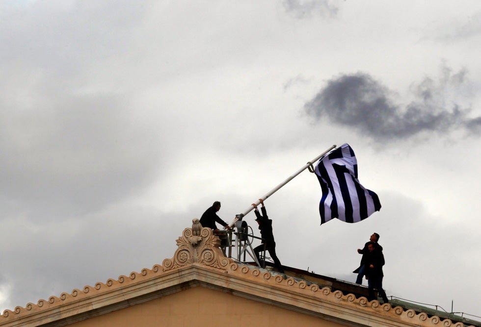Greek parliament employees replace a torn flag atop the parliament building in Athens' Syntagma Square. Yannis Behrakis was previously Reuters' chief photographer for the Israeli and Palestinian territories, before moving to Greece in 2010 to cover the financial crisis. He has been with Reuters since 1987. In 2000, he was wounded while on assignment in Sierra Leone in an ambush. He claims the only reason he was able to get away from the attackers and survive was thanks to "hostile-environment training" he had done five years earlier. You can keep up with his assignments by following his <a href="http://blogs.reuters.com/yannis-behrakis/">Reuters blog</a>.