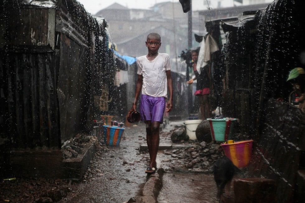 A child stands in pouring rain in the slum of Susan's Bay in Sierra Leone's capital of Freetown. Sierra Leone's government has described the current cholera outbreak in the West African state as a "national emergency." At the height of the wet season, over-populated areas with poor water and sanitation are exacerbating the spread of the disease. Simon Akam is a freelance photo correspondent for Reuters based in Sierra Leone. His career has brought him to some of the furthest reaches of the planet—see his incredible portfolio on his <a href="http://www.simonakam.com/">personal site</a>.