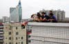 Rescuers and relatives stop a woman from committing suicide by jumping off a building in Zhanjiang, Guangdong province of China.