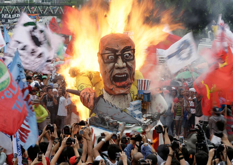 Protesters burn an effigy of Philippine President Benigno Aquino III during a rally to coincide with his fourth State-of-the-Nation Address (SONA) before the country's congressmen and senators Monday July 22, 2013 at the House of Representatives at suburban Quezon city, northeast of Manila, Philippines. President Aquino III is expected to dwell on the gains of his administration particularly on the robust economy but the protesters see otherwise especially on the increasing prices of oil and basic services as water and electricity. (AP Photo/Bullit Marquez)