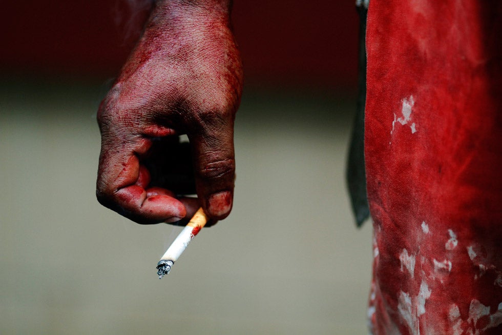 A bleeding Shi'ite Muslim man holds a cigarette as he rests after taking part in the Ashura religious festival in Yangon, Myanmar.