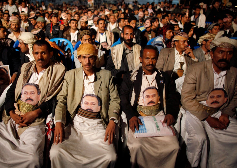 Supporters of Yemen's former president Ali Abdullah Saleh sit with posters of Saleh attached to their belts at a rally marking Saleh's 70th birthday in Sanaa. Saleh stepped down in February after a year of massive protests against his 33-year rule. Khaled Abdullah is a Reuters staff photographer based in Yemen.