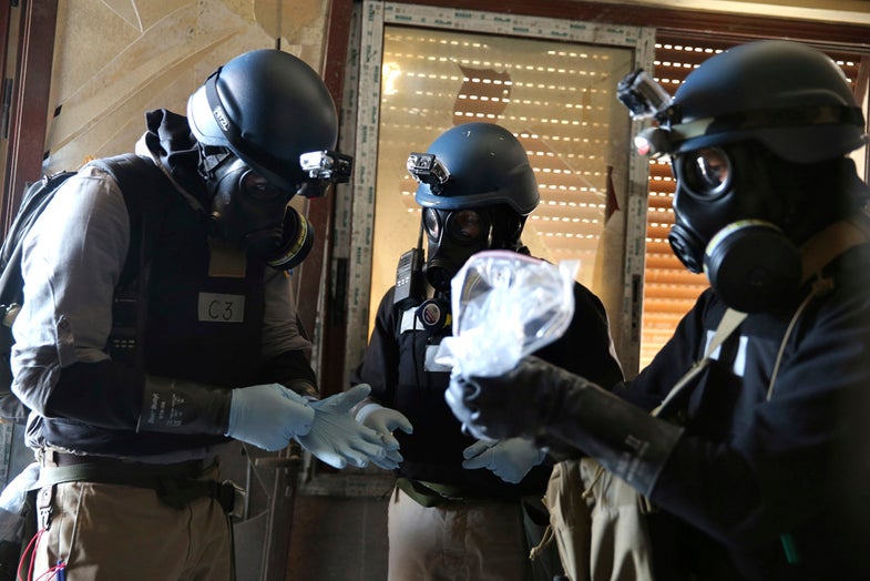 A U.N. chemical weapons expert, wearing a gas mask, holds a plastic bag containing samples from one of the sites of an alleged chemical weapons attack in the Ain Tarma neighbourhood of Damascus August 29, 2013. A team of U.N. experts left their Damascus hotel for a third day of on-site investigations into apparent chemical weapons attacks on the outskirts of the capital. Activists and doctors in rebel-held areas said the six-car U.N. convoy was scheduled to visit the scene of strikes in the eastern Ghouta suburbs. REUTERS/Mohamed Abdullah (SYRIA - Tags: POLITICS CIVIL UNREST CONFLICT TPX IMAGES OF THE DAY) - RTX1306G
