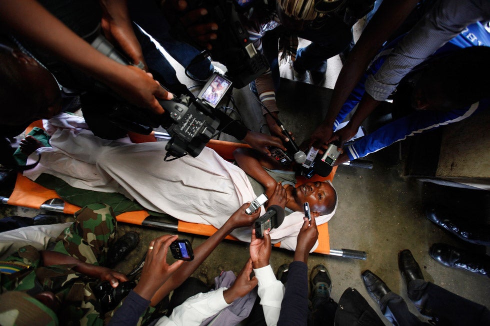 Journalists interview a wounded Rwandan FDLR rebel fighter at a military base in Muti village, 93 miles west of the capital Kigali. James Akena is a Ugandan photographer who has been documenting conflict for much of his life. See more of his work on his <a href="http://www.jamesakena.com/">personal site</a>.