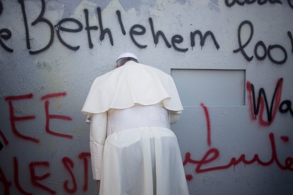 Pope Francis prays at Israel's separation barrier on his way to a mass in Manger Square next to the Church of the Nativity, traditionally believed to be the birthplace of Jesus Christ in the West Bank city of Bethlehem on Sunday, May 25, 2014. Francis called the Israeli-Palestinian stalemate "unacceptable" as he landed Sunday in the West Bank town of Bethlehem in a symbolic nod to Palestinian aspirations for their own state. Ariel Schalit is an AP staffer based in Israel. See more work <a href="http://www.americanphotomag.com/photo-gallery/2014/02/best-photojournalism-month-january-2014?page=9">here</a>.