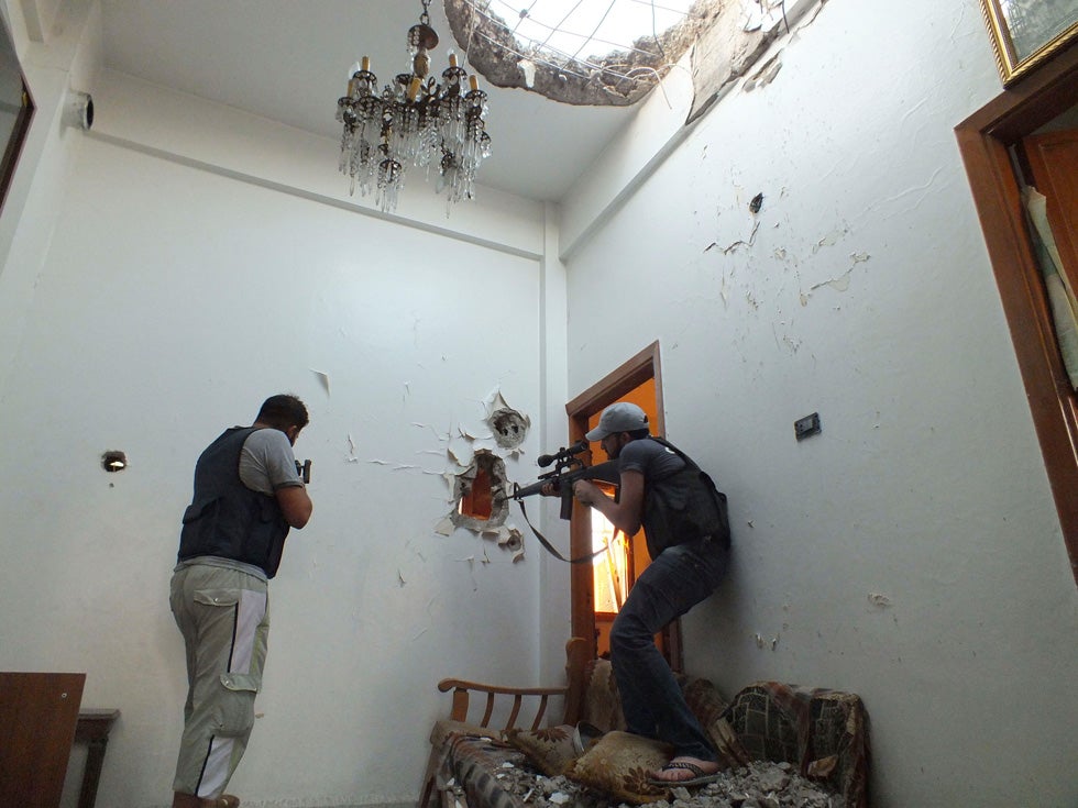 Two members of the Free Syrian Army hold their weapons as they take defense positions in a house in Homs, Syria. Yazen Homsy is a freelance photographer covering the conflict in Syria and submitting work to Reuters.
