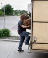 An unknown man lifts Big Foot into a trailer.