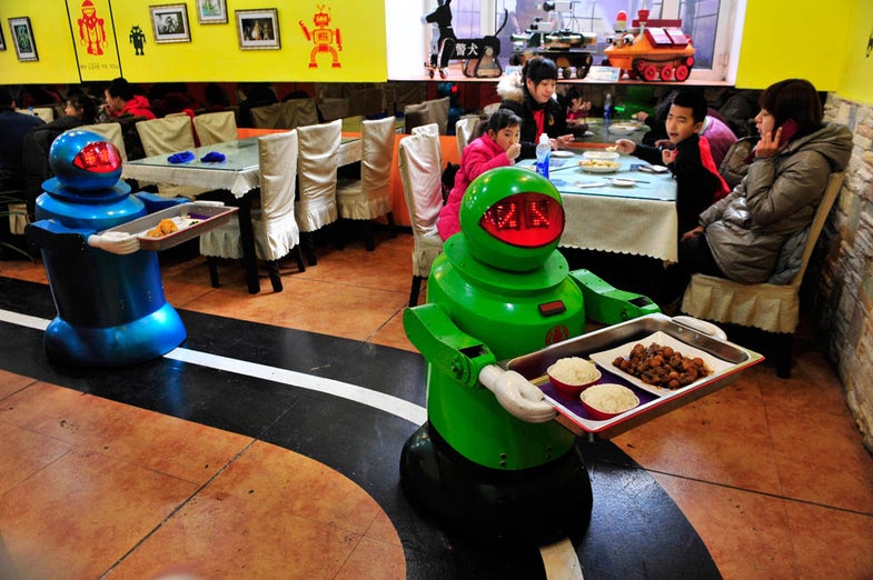 Robots deliver dishes to customers at a Robot Restaurant in Harbin, Heilongjiang province January 12, 2013. Opened in June 2012, the restaurant has gained fame in using a total of 20 robots, which range in heights of 1.3-1.6 metres (4.27-5.25 ft), to cook meals and deliver dishes. The robots can work continuously for five hours after a two-hour charge, and are able to display over 10 expressions on their faces and say basic welcoming sentences to customers, local media reported. REUTERS/Sheng Li (CHINA - Tags: SOCIETY SCIENCE TECHNOLOGY FOOD)
