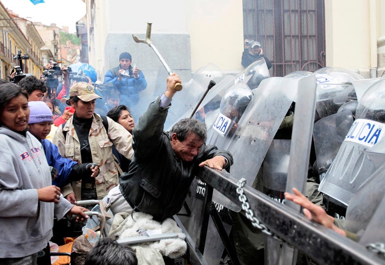 Physically disabled people clash with riot police in the centre of La Paz February 23, 2012. Hundreds of physically disabled people arrived in La Paz on Thursday after completing a protest march of some 1600 km (994 miles) over a hundred days to demand that Bolivia's government offer support in the form of 3000 bolivianos ($434) payment to each physically disabled Bolivian, according to local media. REUTERS/David Mercado (BOLIVIA - Tags: CIVIL UNREST HEALTH BUSINESS POLITICS TPX IMAGES OF THE DAY)