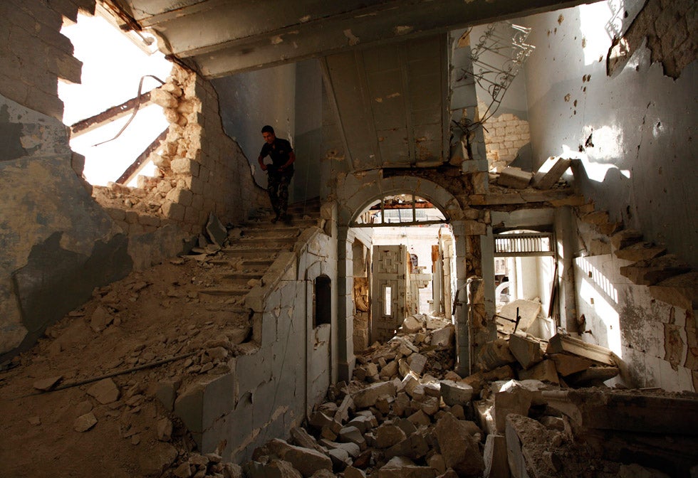 A Free Syrian Army fighter carries his weapon as he walks down the stairs of the damaged former Immigration and Passport building in Aleppo. Hamid Khatib is an independent photojournalist stringing for Reuters in Syria. His images of the Syrian rebel forces are some of the most telling photographs we've see consistently coming out of Syria. See more of them <a href="http://www.americanphotomag.com/photo-gallery/2013/09/photojournalism-month-august-2013?page=4">here</a>, <a href="http://www.americanphotomag.com/article/2013/07/photo-day-soft-light-deir-al-zor">here</a> and <a href="http://www.americanphotomag.com/article/2013/07/photo-day-quiet-reflection-syria">here</a>.