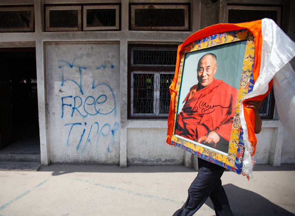 A Tibetan man walks down the street carrying a portrait of the Dalai Lama in Kathmandu, Nepal. Navesh Chitrakar is a Reuters staff photographer based in Nepal. You can see a fantastic portfolio of his work from the region on the <a href="http://in.reuters.com/news/pictures/slideshow?articleId=INRTR2TSMC#a=1">Reuters site</a>.