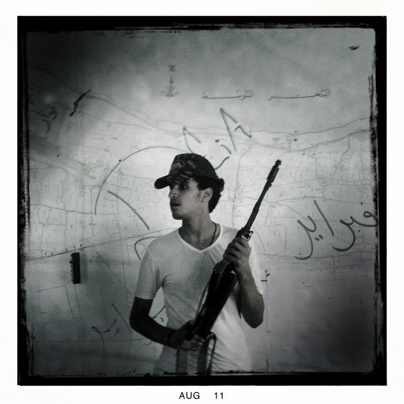 A rebel soldier stands inside an office used by Col. Muammar el-Qaddafi's government to monitor civilian movement using cameras placed throughout the city, Tripoli, Libya on Aug. 30, 2011. 