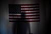 Manny Bojorquez casts a shadow on a flag in his apartment in Mesa, Arizona. He was a member of the 2/7 Marines, which fought in Afghanistan in 2008 and now has a suicide rate more than 10 times higher than the national average. Since the deployment, there have been 14 suicides. Bojorquez, like many of his comrades, has been haunted by the high number of deaths in his battalion and even tried to shoot himself. He has tried to get counseling from the VA, but walked out of a session when he was told to treat the loss of his friends like a bad break up with a girlfriend. The Marines of the 2/7 have since created a database of their members to help stem the suicides by sending the nearest Marine to check on someone who is suicidal. Photographed on Friday, March 27, 2015.