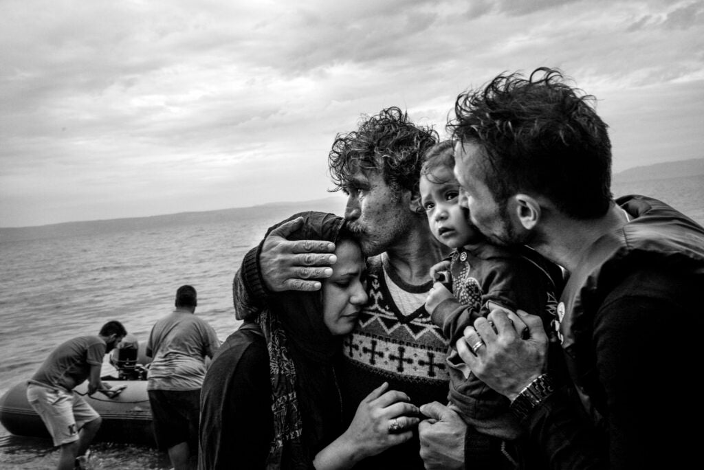 A Syrian family weeps tears of joy after reaching, on a rubber boat from Turkey, the village of Skala Sykaminias located on the northeastern Greek island of Lesbos, on October 10, 2015. Thousand of refugees, mostly coming from Syria, Iraq and Afghanistan, cross everyday the Aegean sea from Turkey to reach Europe: a relatively short but extremely perilous journey. According to the UN Refugee Agency, more than 850 000 arrivals by sea were registered in Greece in 2015.