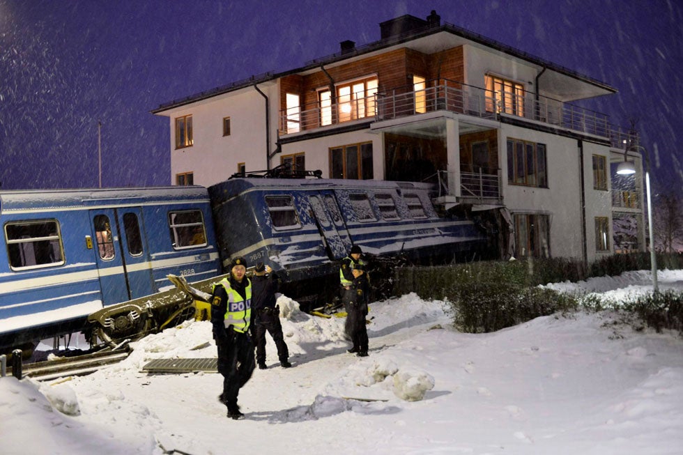 Police officers stand near a local train that derailed and crashed into a residential building in Saltsjobaden outside Stockholm. Jonas Ekstromer is a Swedish-based photojournalist shooting for Scanpix.