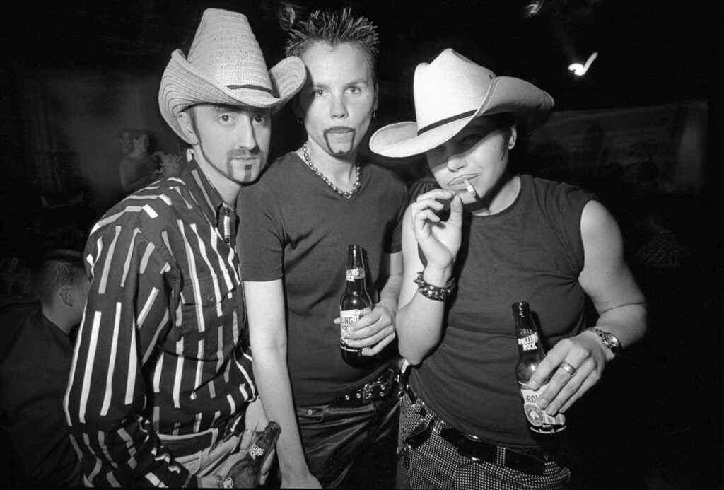 “At first glance you can’t tell that they aren’t men, but then there’s something a little bit off about their body language. Men would never be standing quite that close, or angling their bodies that way. That’s what I love about the picture. The visual tension between the dynamic of them looking like these really butch, possibly scary, men in cowboy hats and the angle of their arms—the way they are grouped together in this more personal way.”