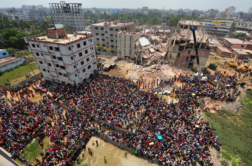 People gather in front of Rana Plaza building as rescue workers continue their life-saving operations. The garment building collapsed without warning, killing hundreds.