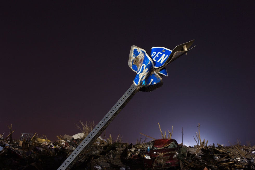 The evening light illuminates a bent street sign in an area heavily damaged by the May 20 afternoon tornado in Moore, Oklahoma May 26, 2013. The tornado was the strongest in the United States in nearly two years and cut a path of destruction 17 miles (27 km) long and 1.3 (2 km) miles wide. REUTERS/Lucas Jackson (UNITED STATES - Tags: DISASTER ENVIRONMENT) - RTX102MS