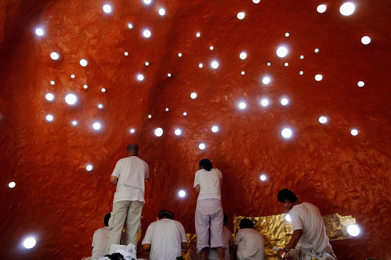 People apply a layer of gold leaf onto the walls of one of the rooms at the Sathira-Dhammasathan Buddhist meditation centre in Bangkok April 21, 2013. The centre, founded in 1987, is a learning community for peace and harmony that has programs open to people regardless of age and gender. REUTERS/Damir Sagolj (THAILAND - Tags: RELIGION SOCIETY) - RTXYUCO