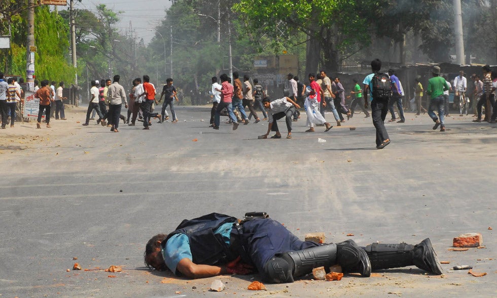 Jahangir Alam, officer in-charge of Upashahar police camp, lies on the street after Jamaat-e-Islami activists smashed pieces of bricks on his head during a clash in Rajshahi, Bangladesh.