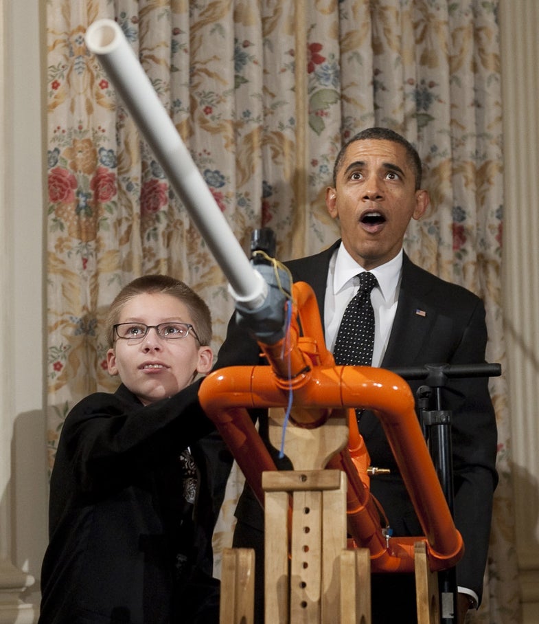 US President Barack Obama reacts as 14-year-old Joey Hudy of Phoenix, Arizona, launches a marshmallow from Hudy's "Extreme Marshmallow Cannon" during a tour of the White House Science Fair in the State Dining Room of the White House in Washington, DC, February 7, 2012. Obama announced new policies to recruit and support science, technology, engineering and math (STEM) teacher programs, including requesting $80 million in his upcoming budget for teacher preparation, with the goal of training one million additional STEM students over the next decade. AFP PHOTO / Saul LOEB (Photo credit should read SAUL LOEB/AFP/Getty Images)