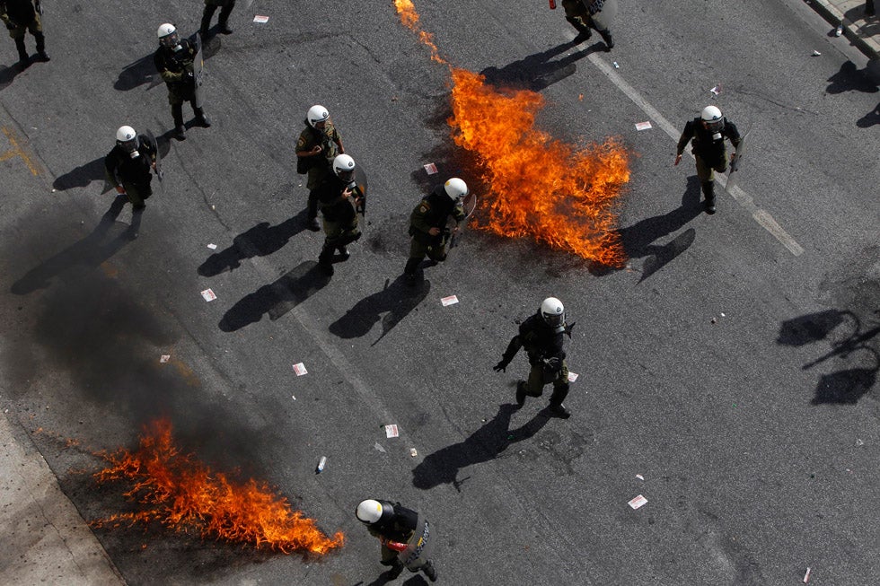 Greek riot police avoid flames from two molotov cocktails at an anti-austerity march in central Athens. John Kolesidis is a photojournalist based in Athens, Greece, shooting for the likes of Reuters and Corbis. He has quite extensively covered anti-austerity protests over the course of the past year and a half.