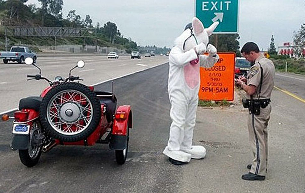 A man dressed as the Easter Bunny is given a warning by California Highway Patrol Officer Adam Griffiths in this CHP handout photo in La Mesa, California. The man was stopped on his motorcycle for not wearing a proper safety helmet and because his costume might impair his vision.
