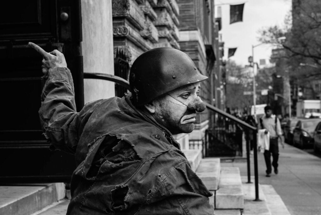 "Walking by the NYU area in Soho, I stumbled upon this Clown dressed as if he just arrived from war. He never spoke a word or acknowledged anyone's existence, just stood on a stoop of a church pointing at it."